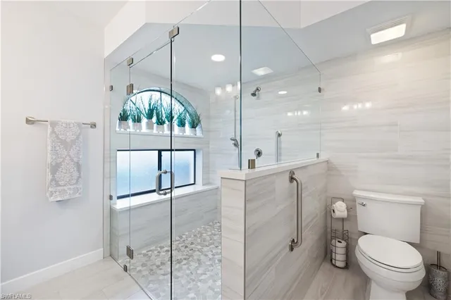 a bathroom with a toilet a sink a mirror and vanity