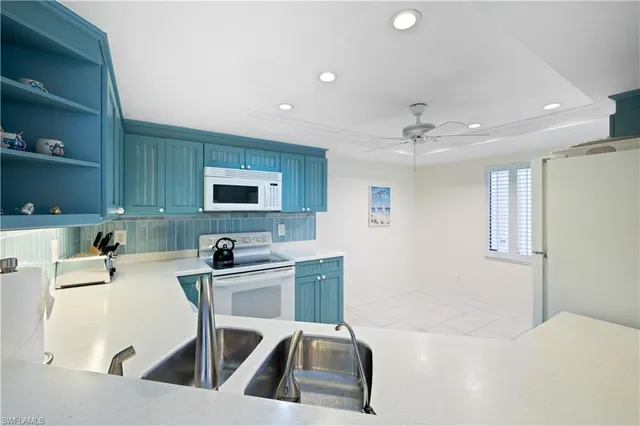 a kitchen with a sink a counter top space cabinets and appliances