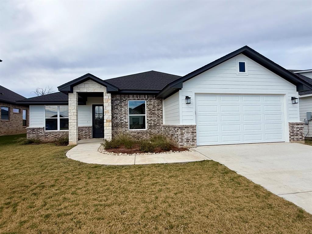 5409 Black Horse Court Waco, TX 76708 - Photo 1 of 1 View of front of house featuring a front yard, driveway, brick siding, and a shingled roof