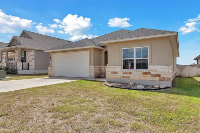 a view of a house with a yard and garage
