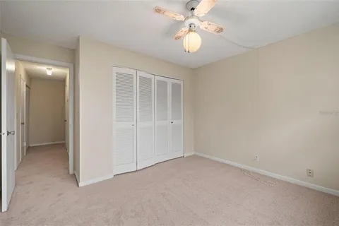 an empty room with a chandelier fan