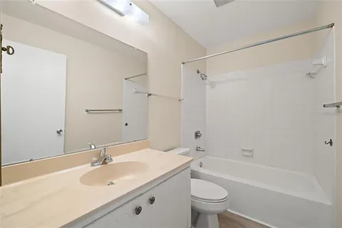 a bathroom with a sink toilet tub vanity and shower