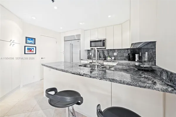 a kitchen with stainless steel appliances granite countertop a sink a stove and a refrigerator