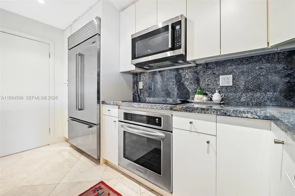 a kitchen with granite countertop cabinets stainless steel appliances and wooden floor