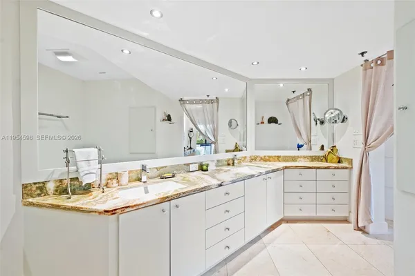 a bathroom with a granite countertop sink double vanity and a mirror