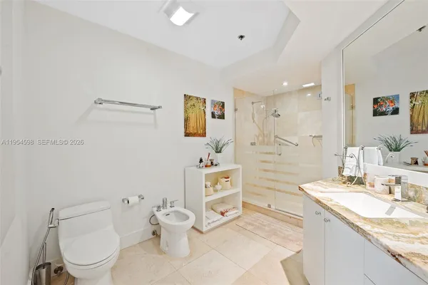 a bathroom with a granite countertop sink mirror vanity and toilet