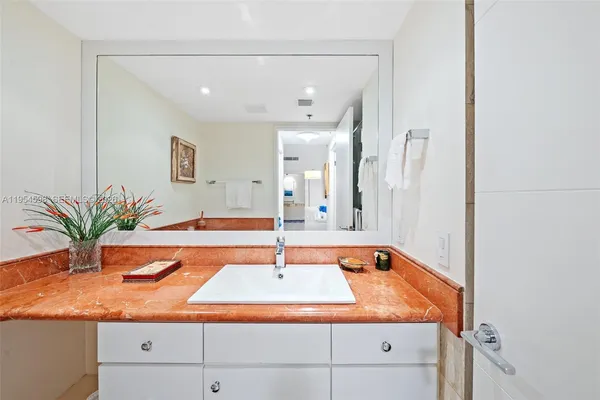 a bathroom with a granite countertop sink and a mirror