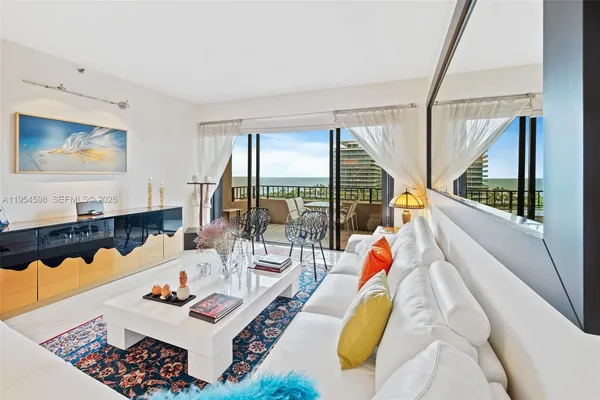 a living room with furniture and floor to ceiling windows