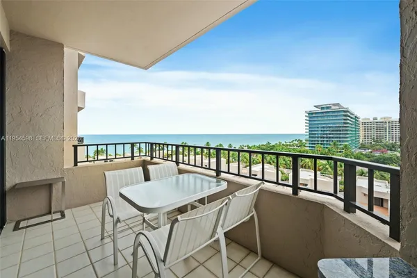 a balcony with a table and chairs