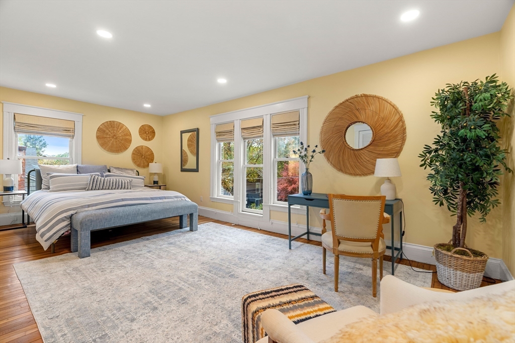 15 Harris Avenue Boston, MA 02130 - Photo 16 of 27 a bedroom with a bed a table and chair with wooden floor