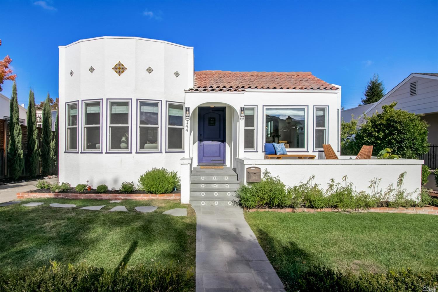 a view of a white house with a big yard and potted plants