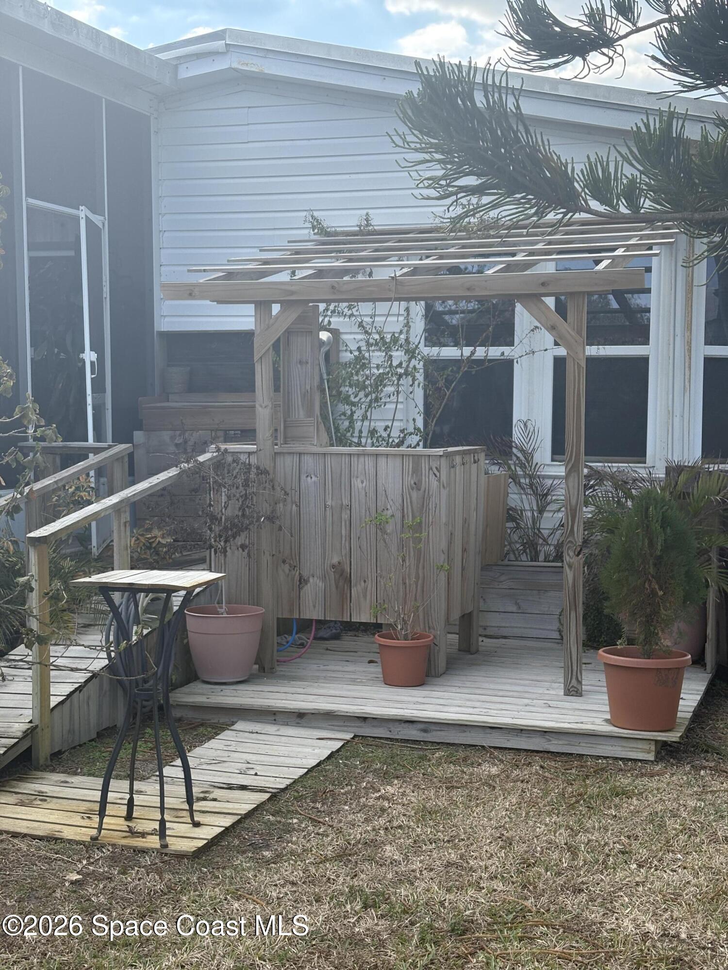 7625 Longhorn Avenue, Unit P3 Micco, FL 32976 - Photo 14 of 40 a view of a patio with table and chairs potted plants