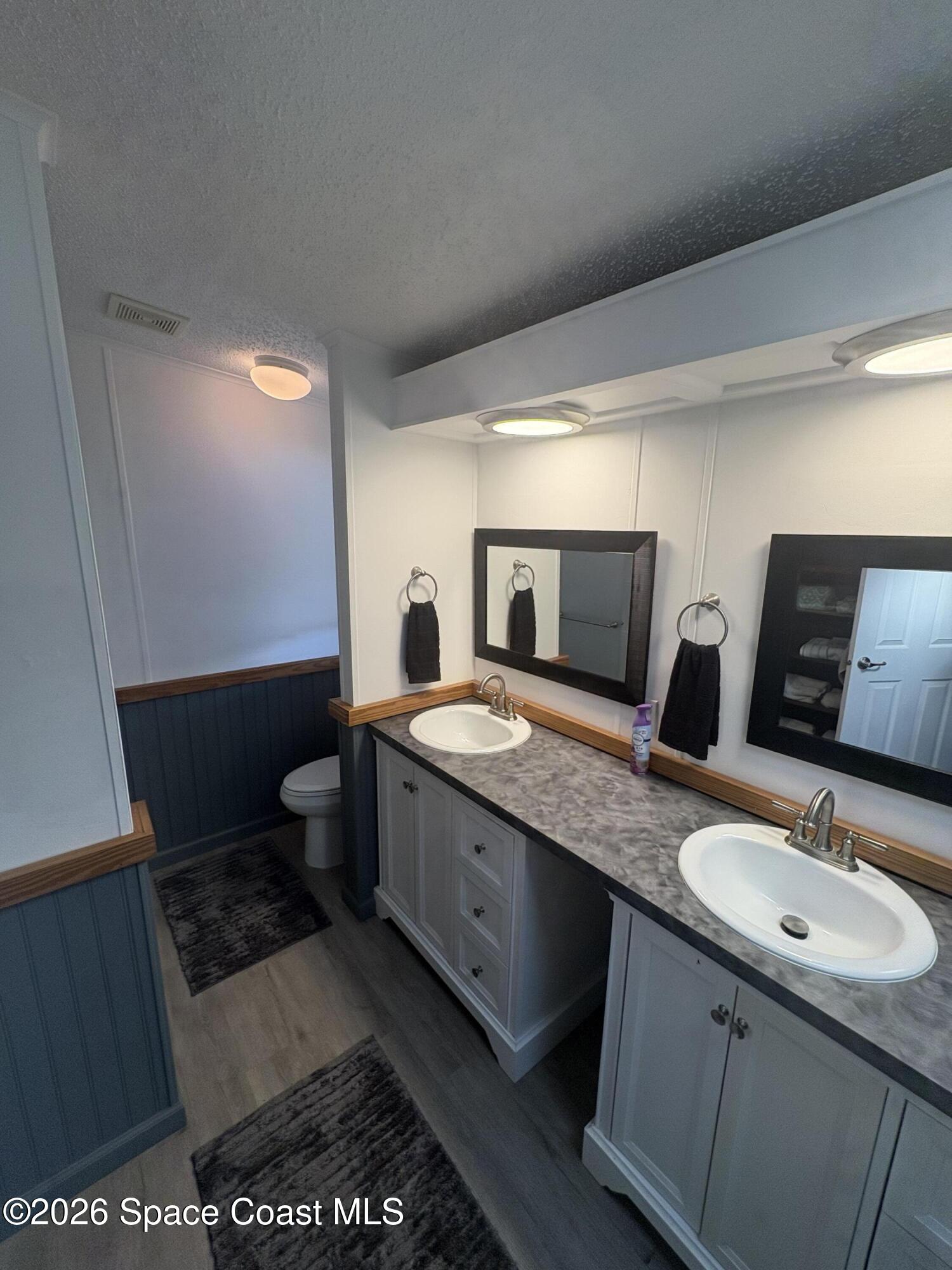 7625 Longhorn Avenue, Unit P3 Micco, FL 32976 - Photo 30 of 40 a bathroom with 2 sink and a mirror