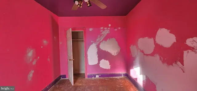 a view of hallway with window and a ceiling fan