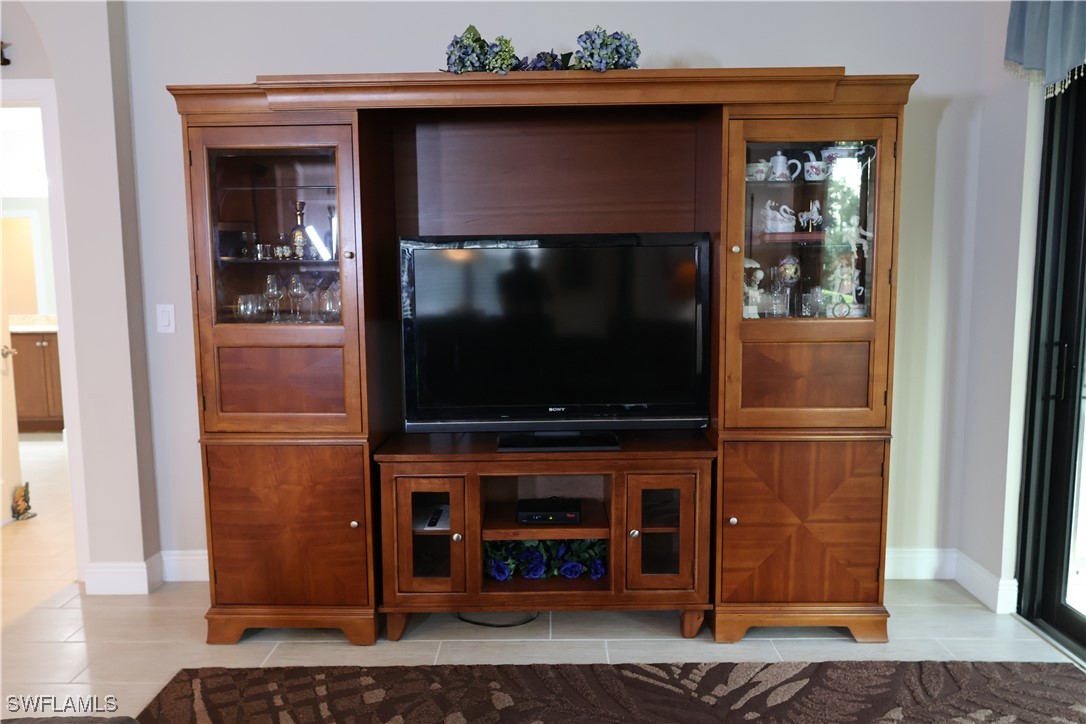 10459 Casella Way, Unit 102 Fort Myers, FL 33913 - Photo 13 of 29 a living room with a fireplace and a flat screen tv