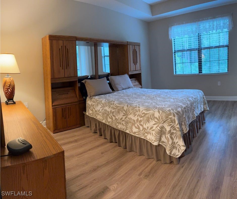 10459 Casella Way, Unit 102 Fort Myers, FL 33913 - Photo 16 of 29 a bedroom with a bed and wooden floor
