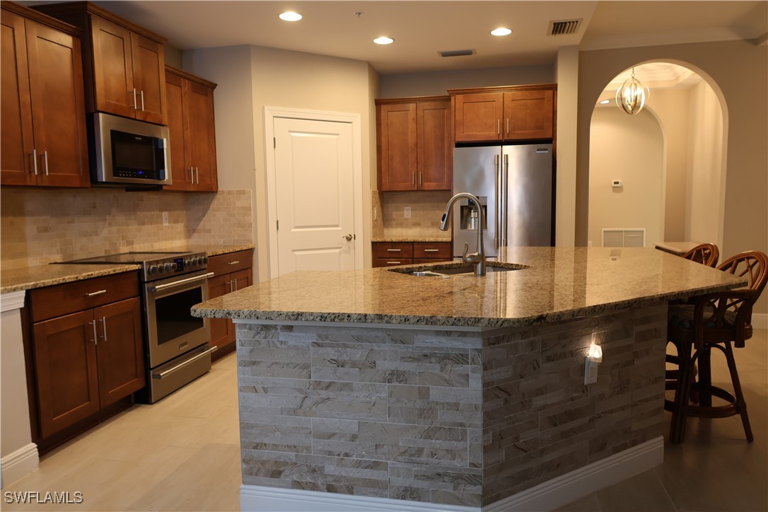 10459 Casella Way, Unit 102 Fort Myers, FL 33913 - Photo 8 of 29 a kitchen with stainless steel appliances granite countertop a stove a sink and a microwave