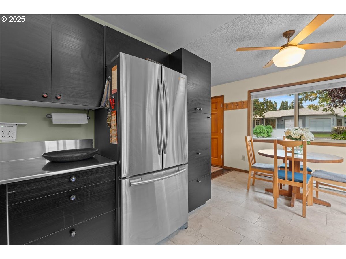 3837 North Juneau Street Portland, OR 97203 - Photo 11 of 32 a kitchen with stainless steel appliances kitchen island granite countertop a refrigerator and a wooden cabinets