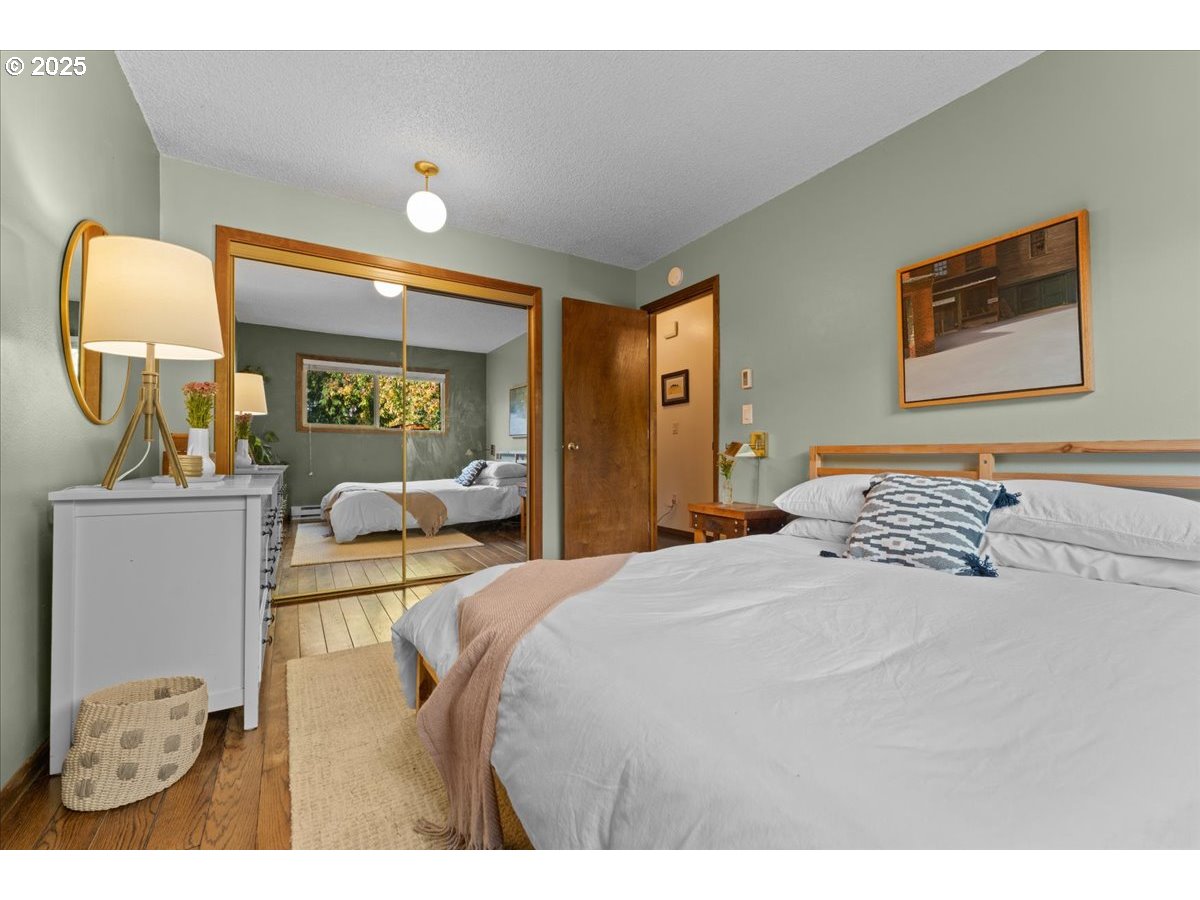 3837 North Juneau Street Portland, OR 97203 - Photo 14 of 32 a bedroom with a bed and dresser with mirror