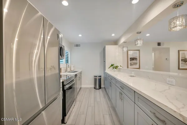 a large kitchen with a sink and refrigerator
