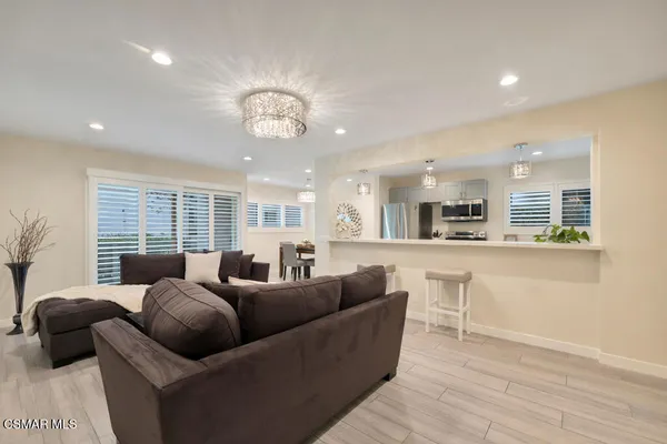 a living room with furniture wooden floor and a large window