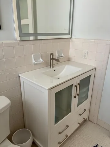 a white toilet sitting next to a bathroom sink