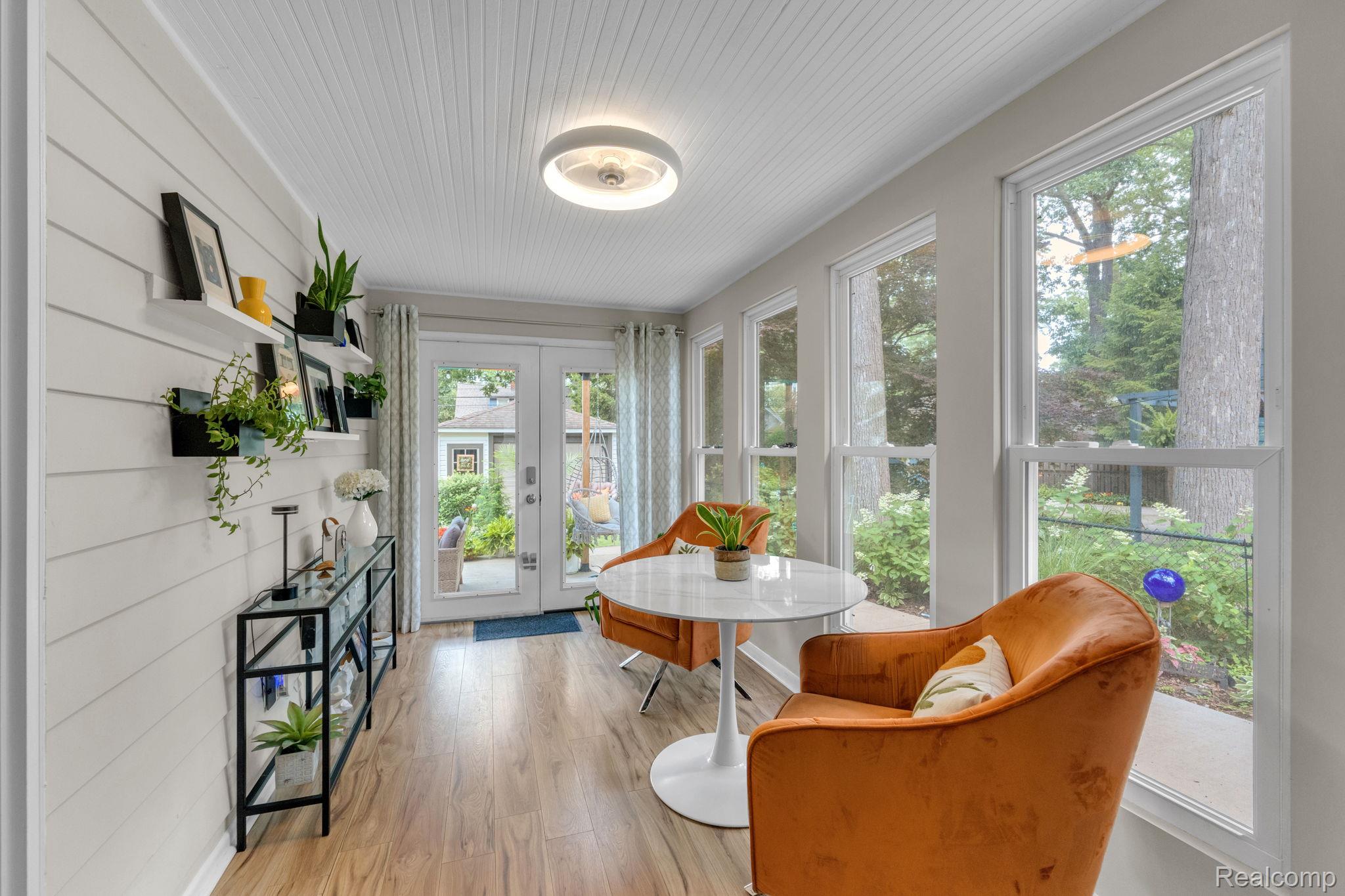 21 Devonshire Road Pleasant Ridge, MI 48069 - Photo 20 of 35 Sun-drenched interior space featuring wood-finish flooring, white shiplap wall paneling, and an exposed beadboard ceiling