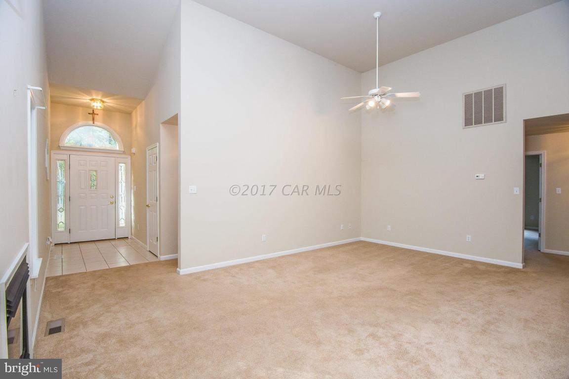 49 Beaconhill Road Ocean Pines, MD 21811 - Photo 2 of 62 an empty room with a chandelier fan and a window
