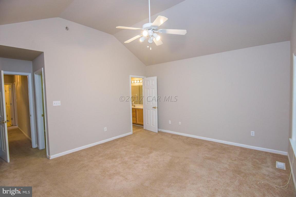 49 Beaconhill Road Ocean Pines, MD 21811 - Photo 11 of 62 an empty room with chandelier fan and windows