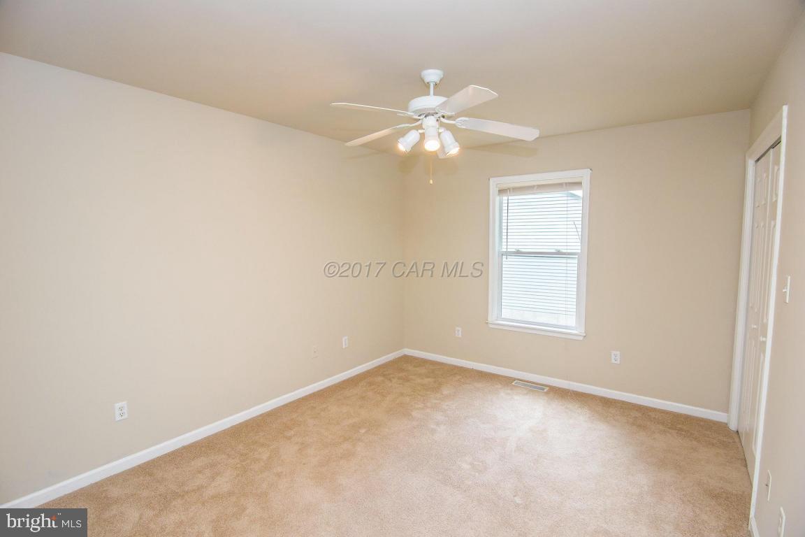 49 Beaconhill Road Ocean Pines, MD 21811 - Photo 15 of 62 an empty room with windows and chandelier fan