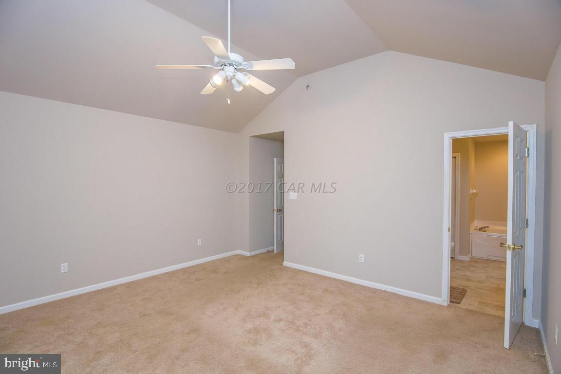 49 Beaconhill Road Ocean Pines, MD 21811 - Photo 36 of 62 an empty room with a chandelier fan and windows