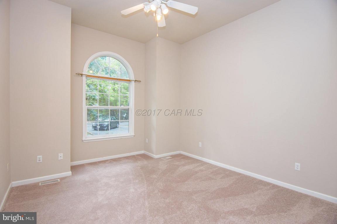 49 Beaconhill Road Ocean Pines, MD 21811 - Photo 41 of 62 an empty room with a chandelier fan and windows