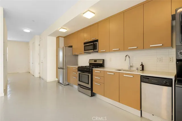 a kitchen with stainless steel appliances granite countertop a refrigerator sink and cabinets