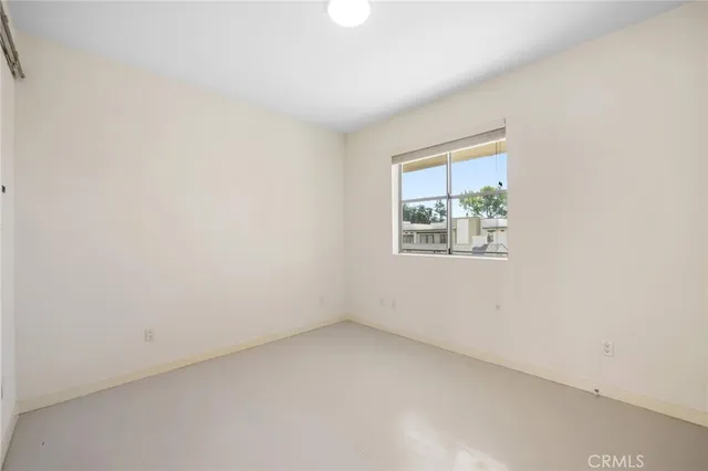 an empty room with wooden floor and a bathroom