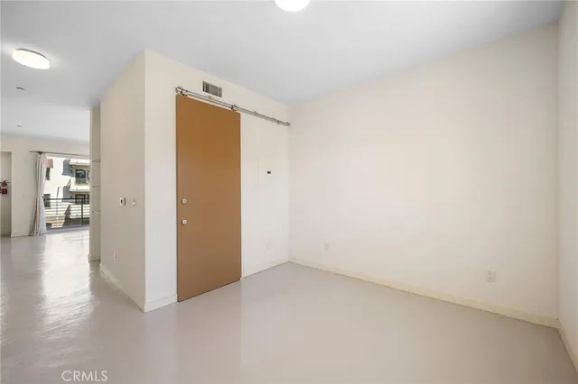 an empty room with wooden floor and a bathroom