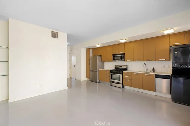 a kitchen with stainless steel appliances refrigerator sink and stove