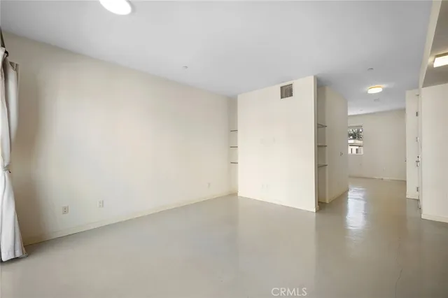 a view of a big room with wooden floor and a window
