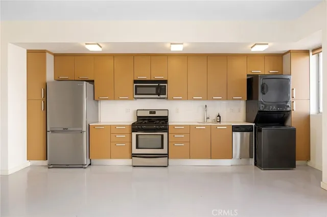 a kitchen with stainless steel appliances a stove a microwave sink and cabinets