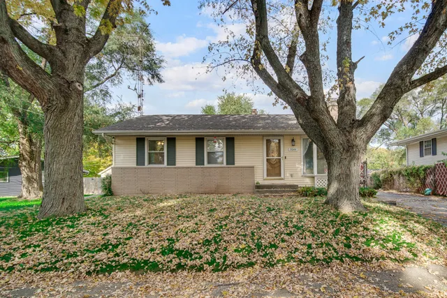 a front view of house with yard and trees around
