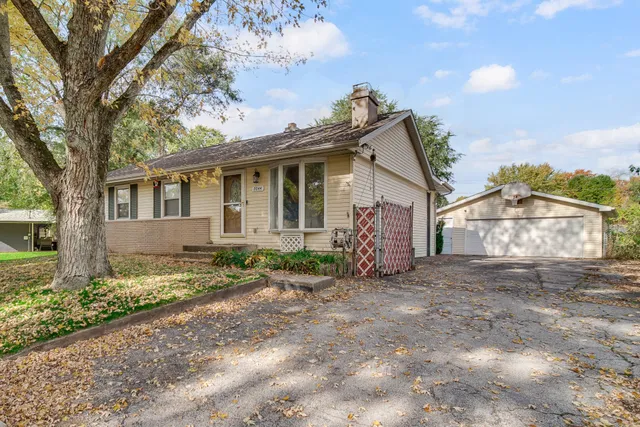 a view of a house with a yard and large tree