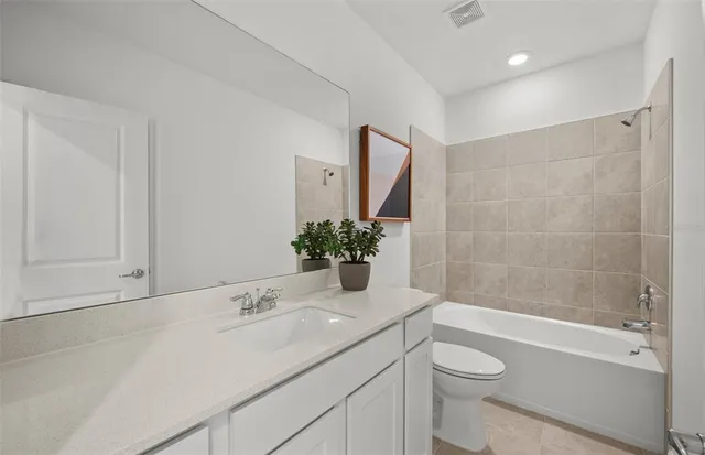 a bathroom with a granite countertop sink a toilet and shower