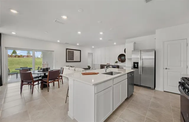 a kitchen with a sink and chairs