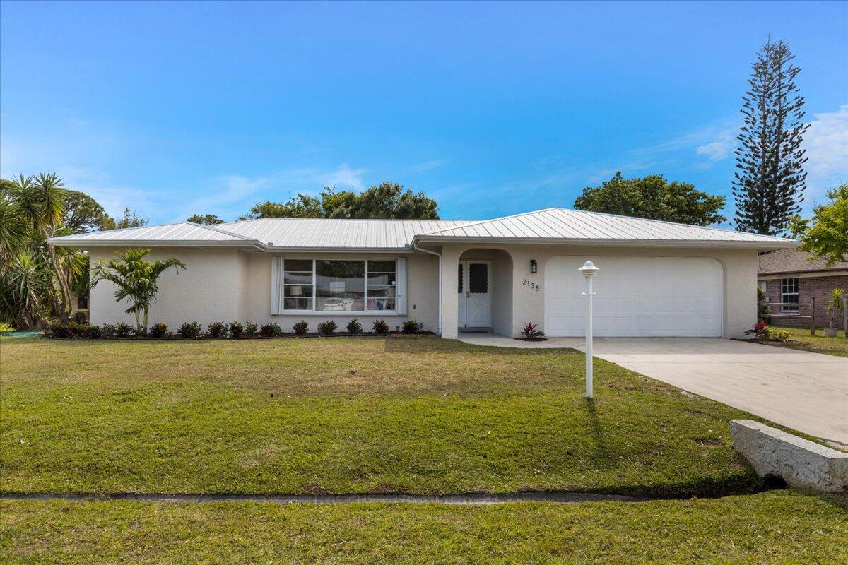 2138 Southeast Dolphin Road Port St. Lucie, FL 34952 - Photo 1 of 31 a front view of a house with a yard