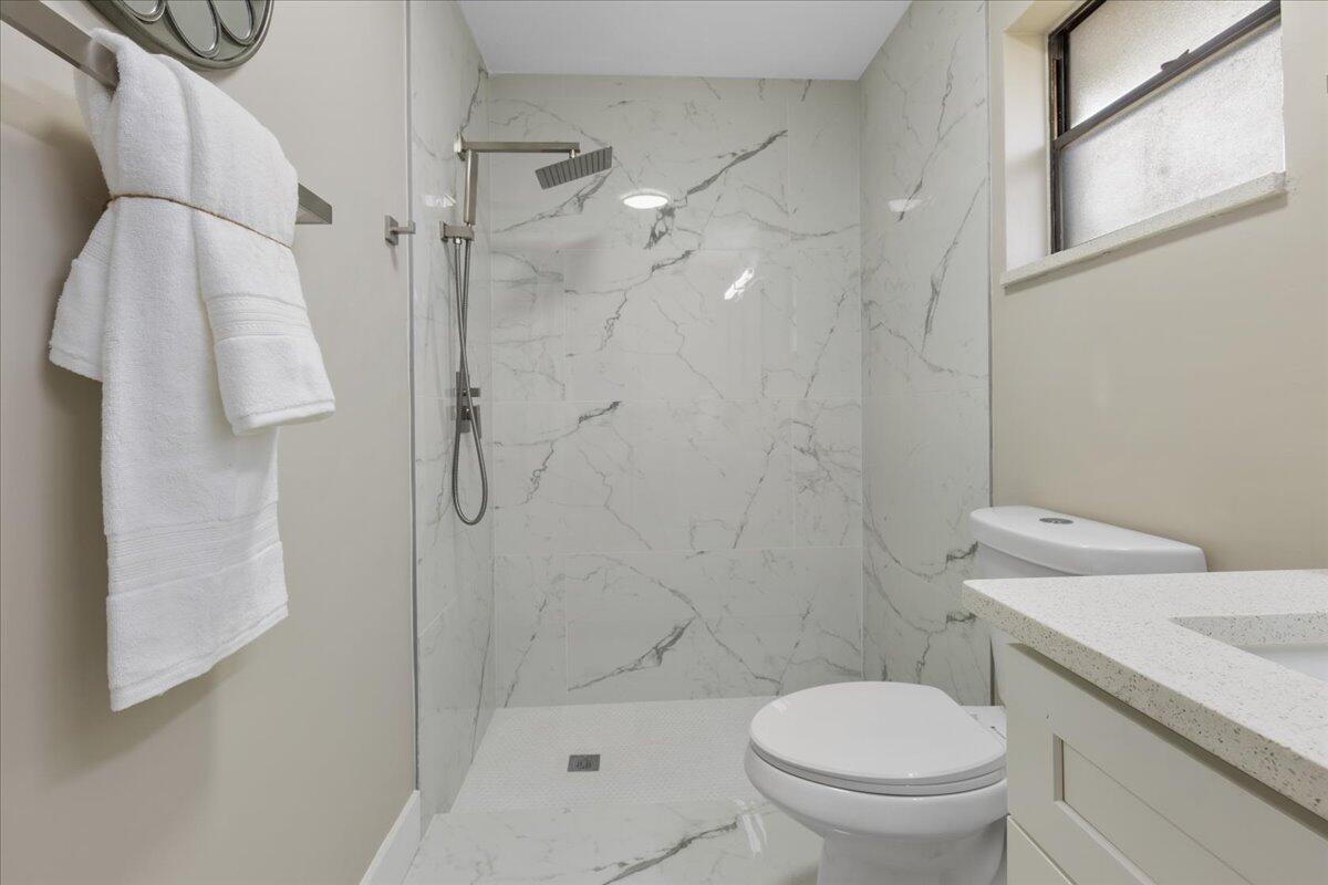 2138 Southeast Dolphin Road Port St. Lucie, FL 34952 - Photo 11 of 31 a white toilet sitting next to a bathroom sink