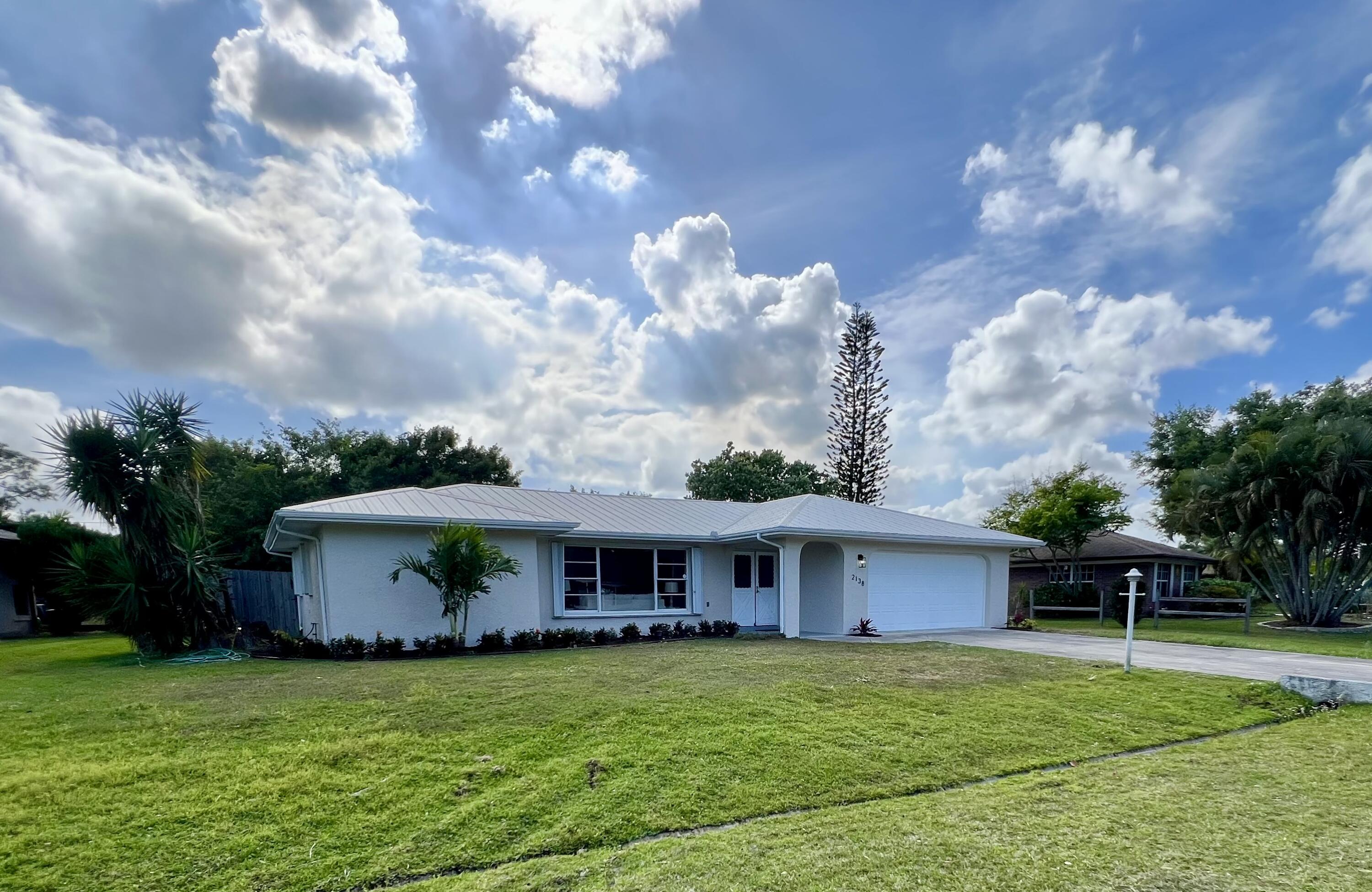 2138 Southeast Dolphin Road Port St. Lucie, FL 34952 - Photo 2 of 31 a front view of a house with garden