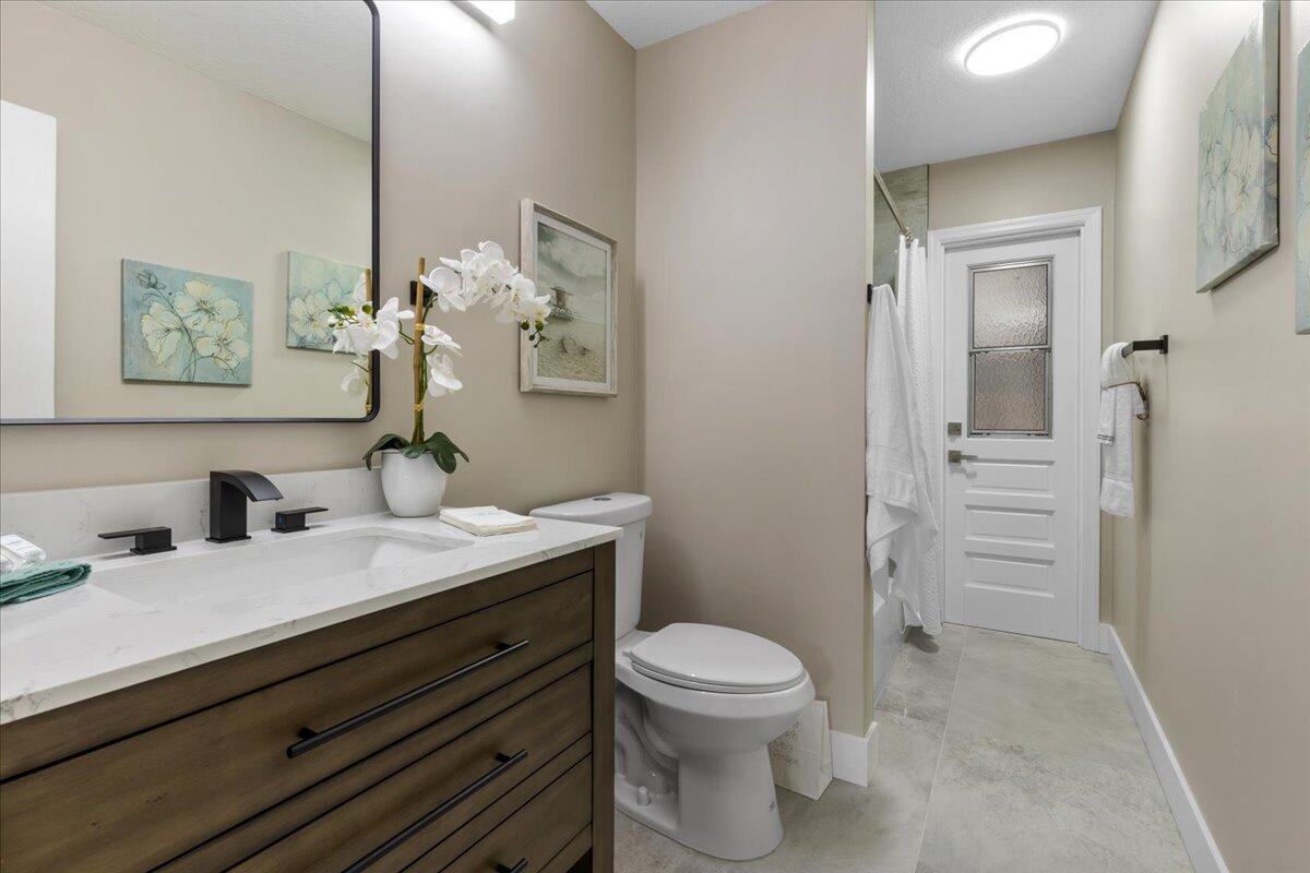 2138 Southeast Dolphin Road Port St. Lucie, FL 34952 - Photo 21 of 31 a bathroom with a sink a toilet and vanity