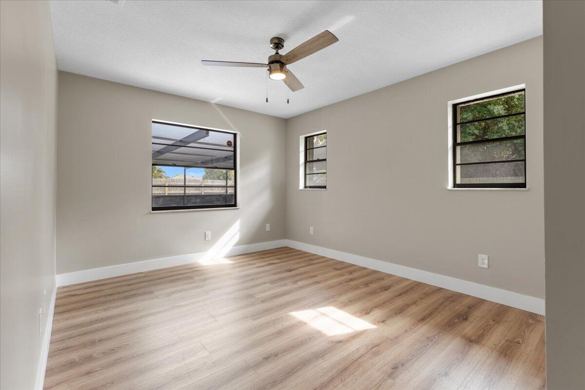2138 Southeast Dolphin Road Port St. Lucie, FL 34952 - Photo 23 of 31 a view of empty room with wooden floor and fan