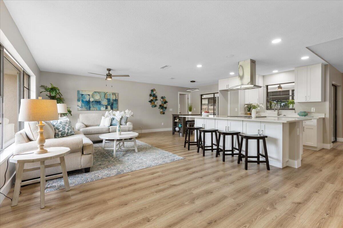2138 Southeast Dolphin Road Port St. Lucie, FL 34952 - Photo 4 of 31 a living room with kitchen island furniture and a wooden floor
