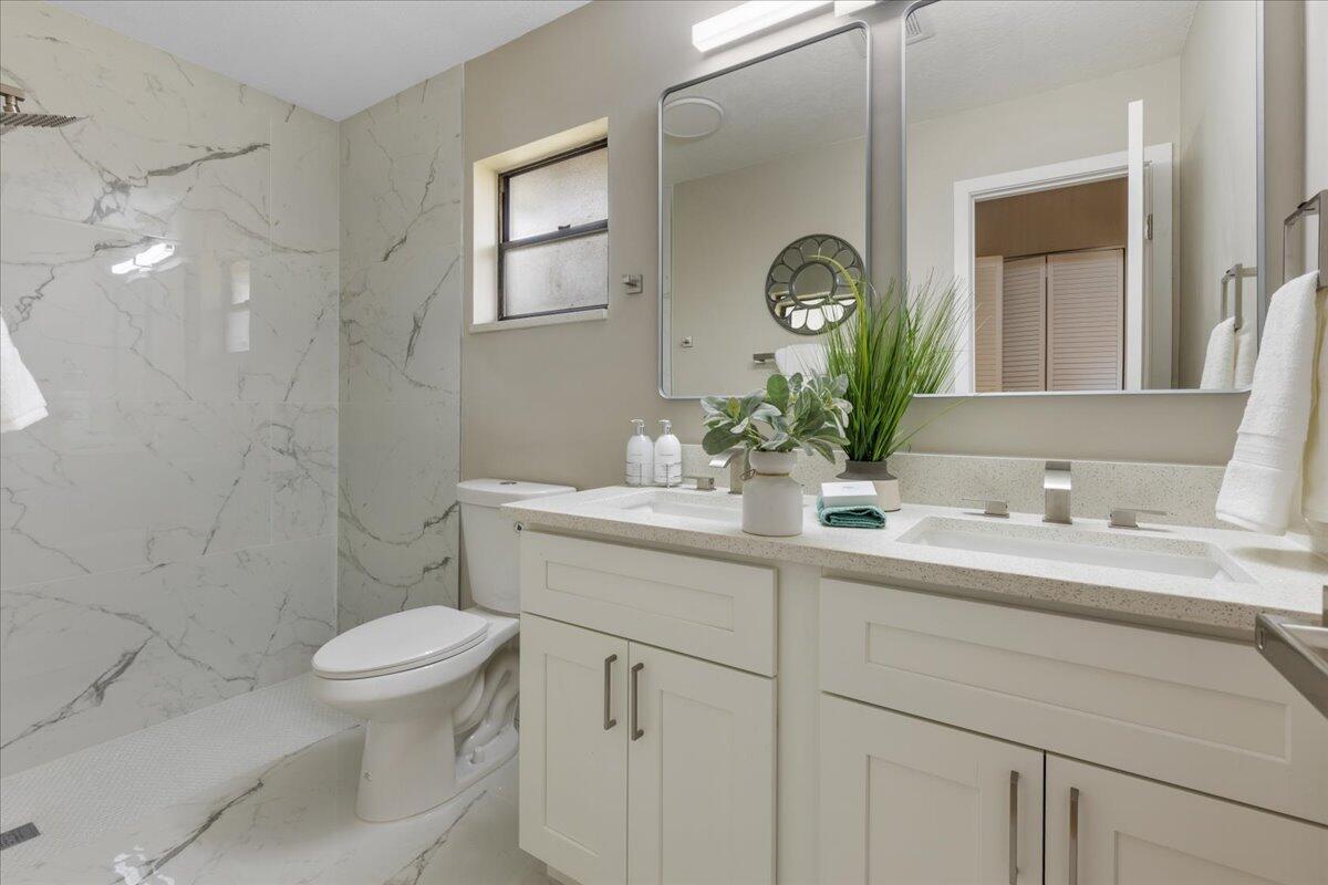 2138 Southeast Dolphin Road Port St. Lucie, FL 34952 - Photo 10 of 31 a bathroom with a toilet sink and mirror