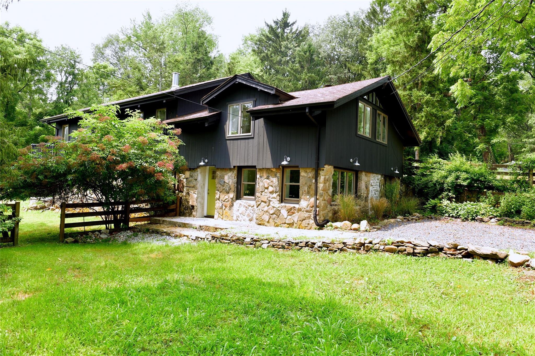 a front view of a house with a garden and trees